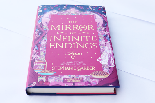Livro de capa dura The Mirror of Infinite Endings, capa rosa ilustrada.