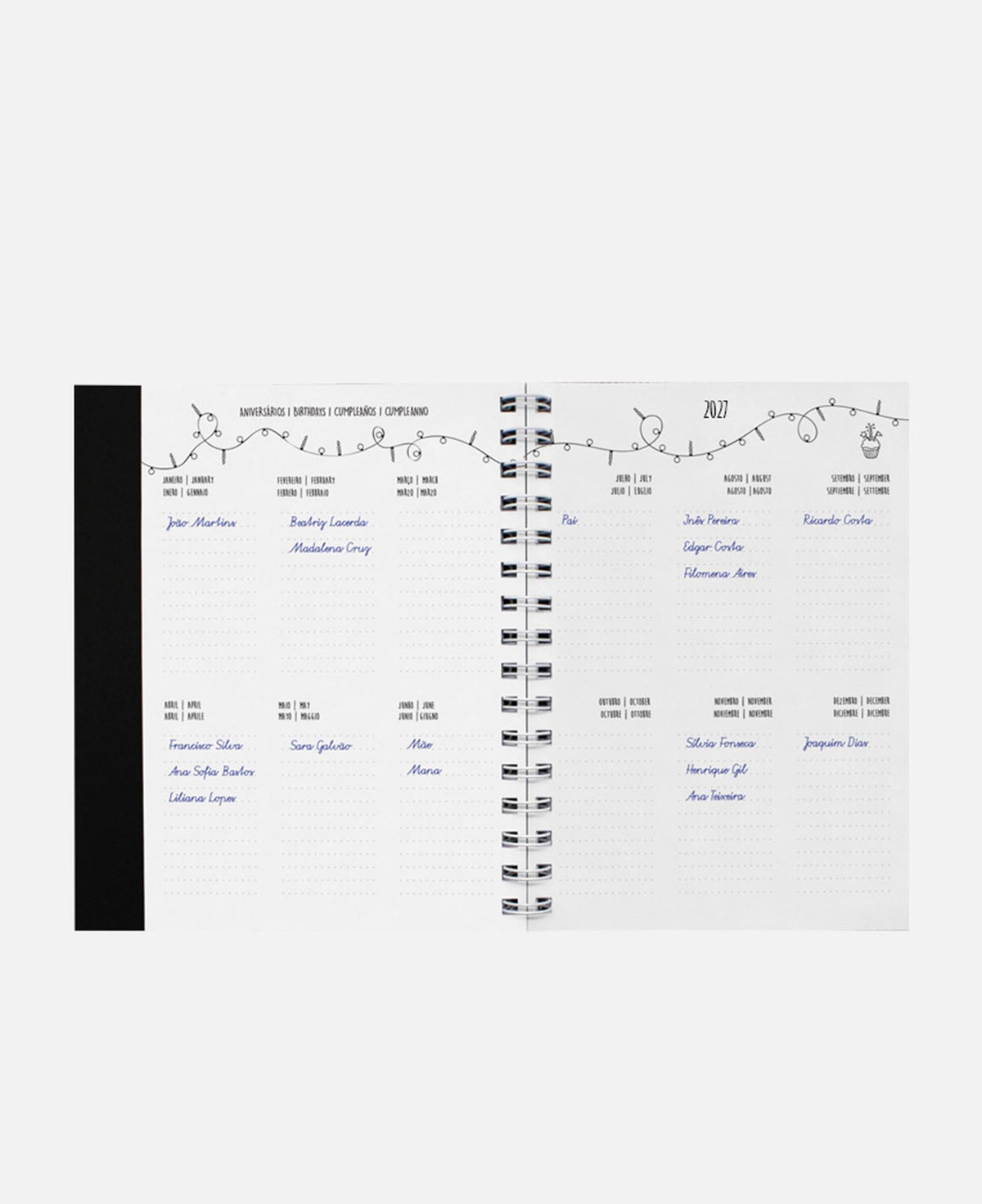 Agenda A5 aberta com espiral; duas páginas com calendário e linhas de anotações