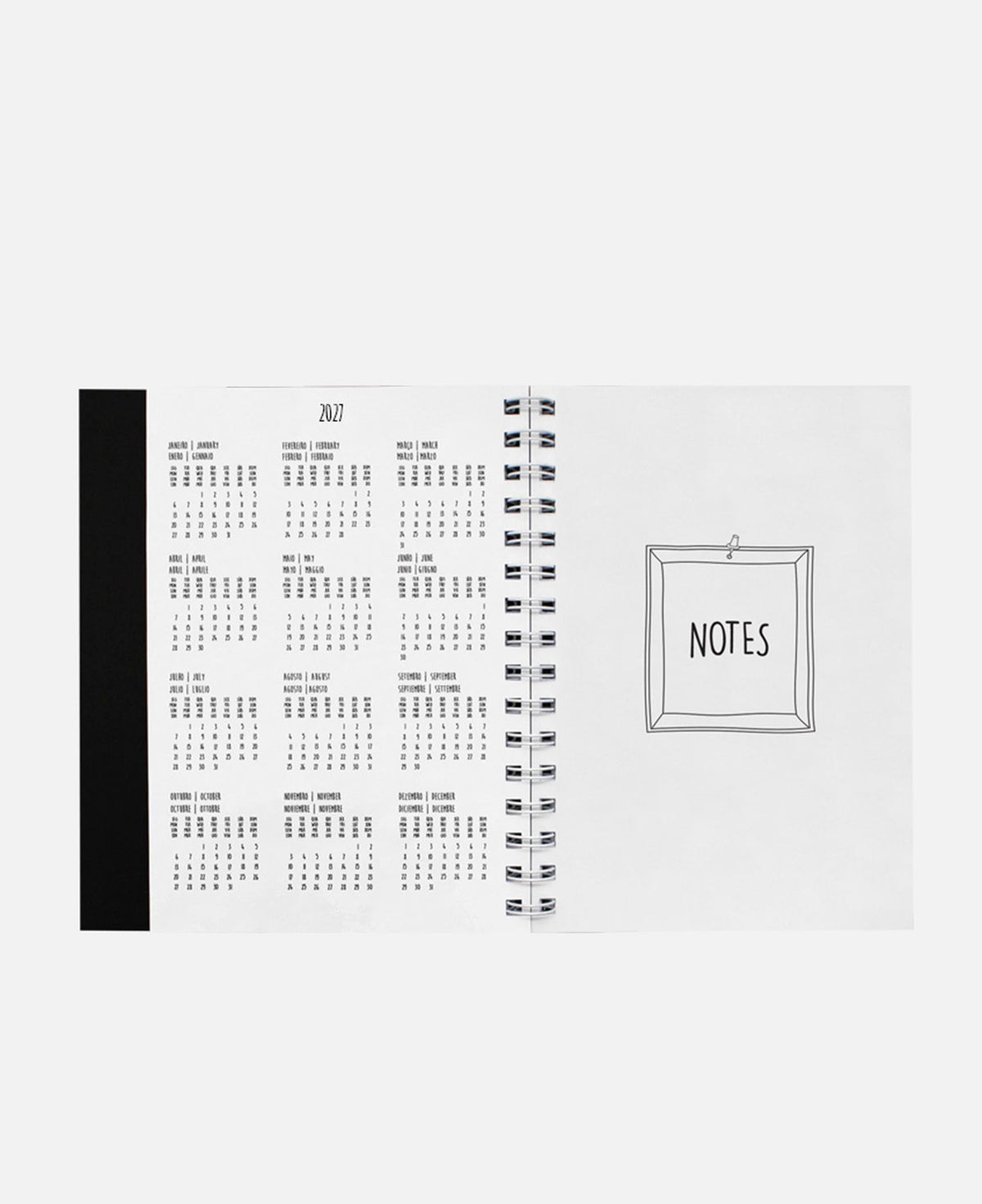Agenda A5 aberta com espiral; calendário de um mês e desenho “NOTES”