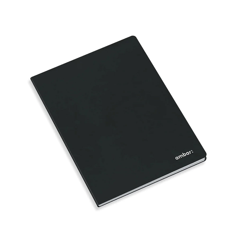 Caderno agrafado Ambar A4 de capa preta, aberto exibindo folhas brancas lisas sem pauta, design minimalista para desenho e escrita livre.