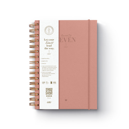 Agenda diária de 2027 Eco Millie com capa de design ecológico, encadernação em espiral e fecho de elástico disposta sobre uma secretária de trabalho.
