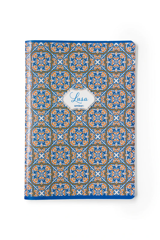 Sebenta A5 da coleção Ambar Lusa Tile com capa inspirada em padrões de azulejos tradicionais portugueses em tons de azul e branco, sobre fundo branco.