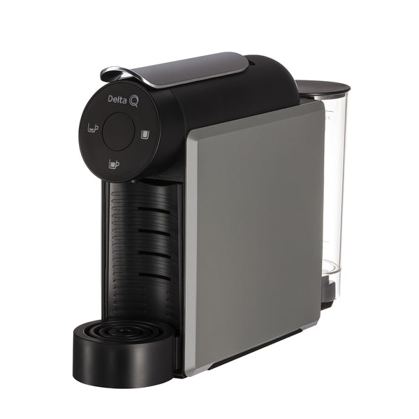 Máquina de café de cápsulas Delta Q Mini Cool com design minimalista e estreito, exibindo os botões de controlo no topo e a bandeja de gotejamento ajustável.